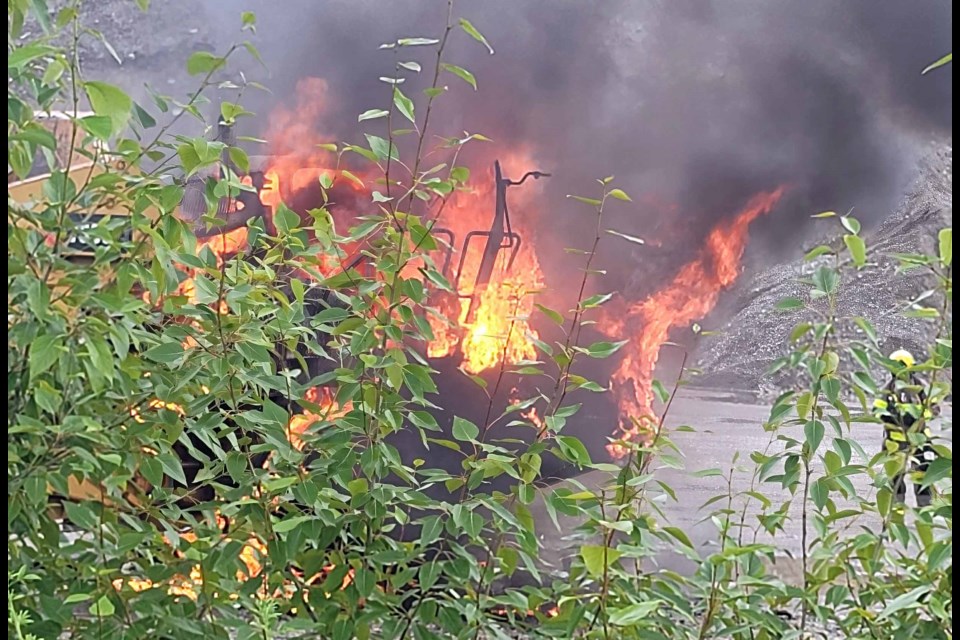 A firefighter from Prince George Fire Rescue gets set to turn on the hose to douse a rock truck that caught on fire while parked in a gravel pit off Otway Road on Thursday, June 26, 2025.