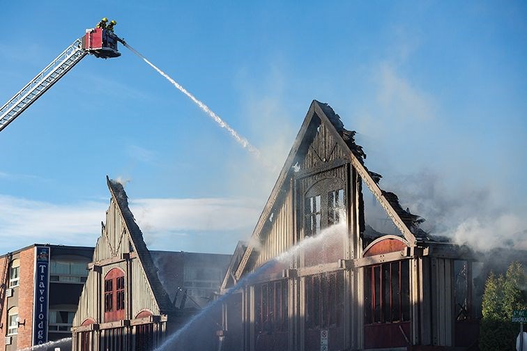 Firefighters continue to pour water on the scene of afire Sunday morning which destroyed the fomer home of RE/MAX Centre City Realty at 611 Brunswick St.