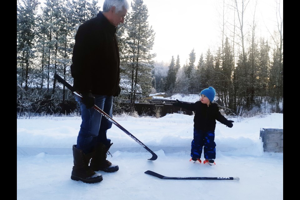 Leroy Manning and his two-year-old grandson Connor get out for some fun on the outdoor rink the Manning family has built on an empty lot on McTavish Road.
