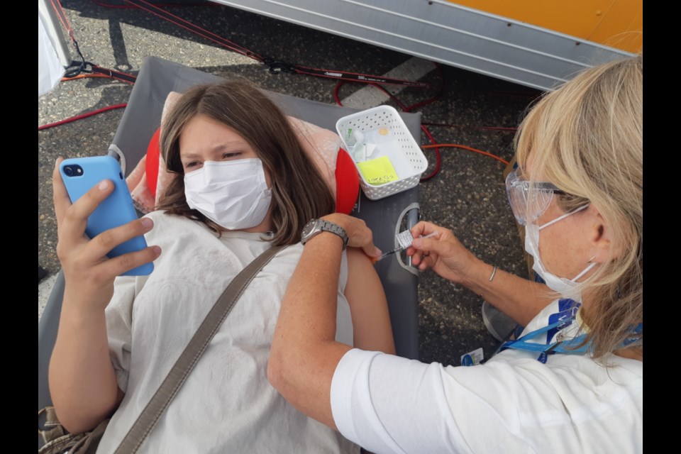 Helaina Lang, 16, receives her second dose of the Pfizer vaccine from registered nurse Christine McGynn Saturday afternoon at the Northern Health COVID-19 pop-up immunization clinic at Exhibition Park. 