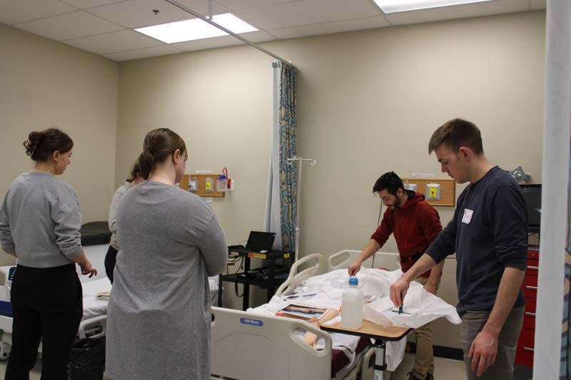 Students at a station at the wound care and naloxone workshop. 