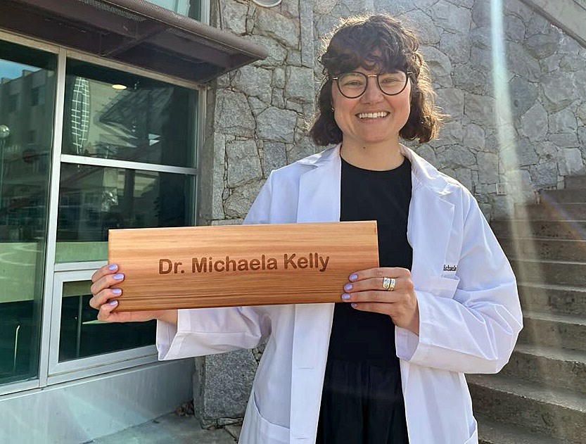 Dr. Michaela Kelly receives her cedar nameplate shingle at the Northern Medical Program's informal graduation ceremony Thursday, April 17, 2025 at the agora at UNBC. Kelly and her classmates will have their formal convocation ceremony at UBC in Vancouver on May 21.