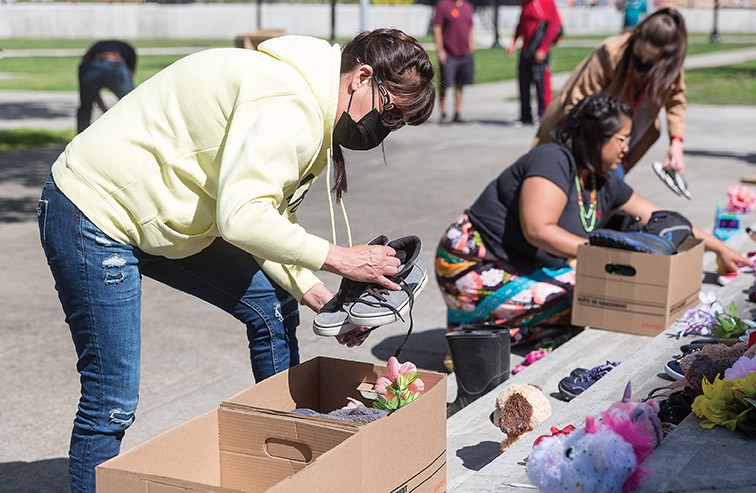 Citizen Photo by James Doyle/Local Journalism Initiative. Lheidli T'enneh Chief Dolleen Logan helps box up some items from the memorial for the remains of the 215 children that were recently discovered on a former residential school site in Kamloops. The items were collected from the steps of city hall on Friday afternoon and moved to The Exploration Place where it will be safely stored until a decision is made on a permanent memorial.