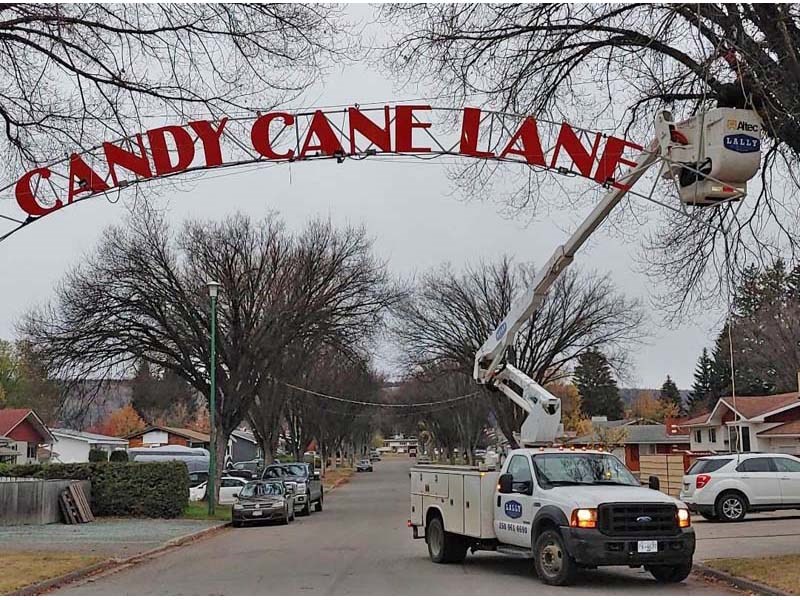 A bucket truck is used to hang the Candy Cane Lane sign every year. 