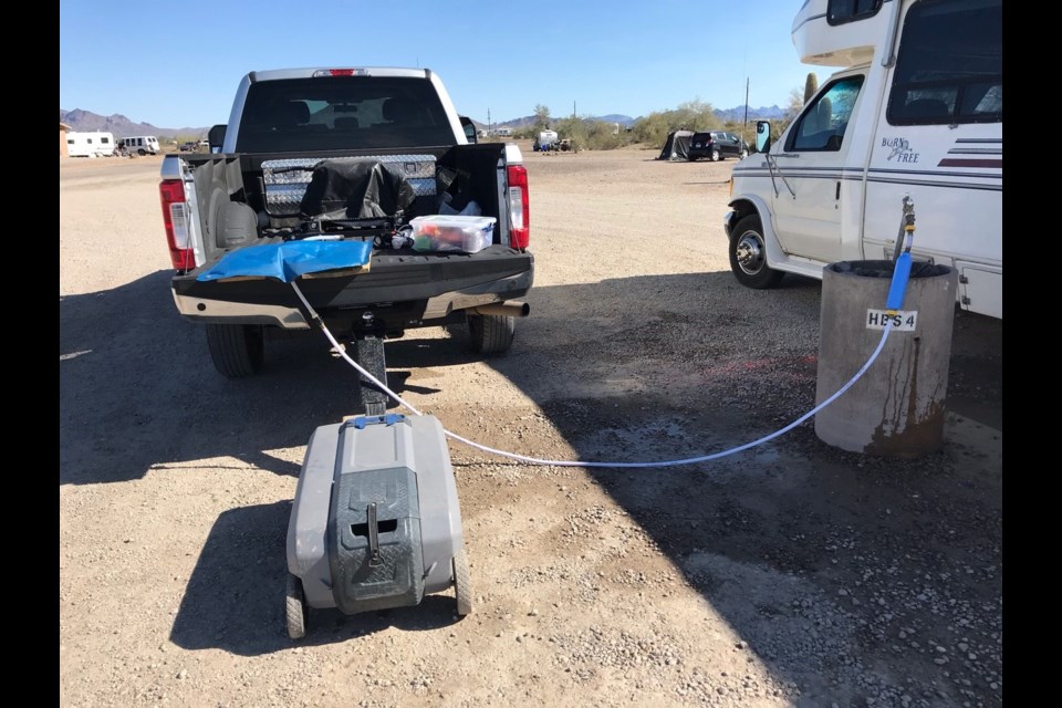 Taking on fresh water into the bladder while towing the sewage tote behind the truck.