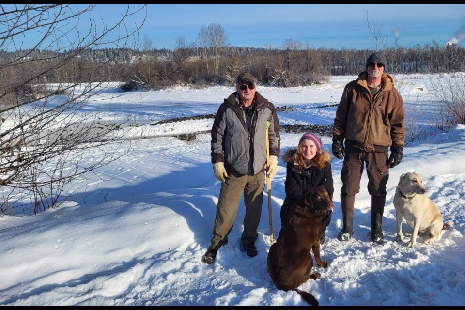 Paul Cailleaux, left, and Brock Bailey, are seen here with Anna Cailleaux Cauley, who are at Cottonwood Island Park to feed the ducks that stay in Prince George for the winter. Paul's dog Reese and Brock's dog Bree keep the group company.