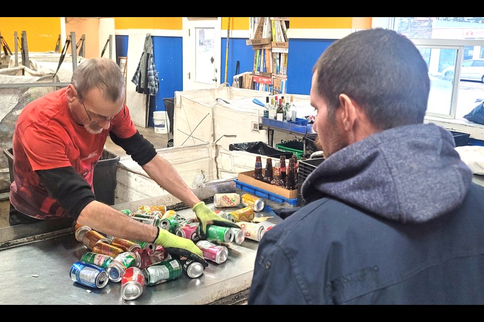 Derek Brown of Nechako Bottle Depot sorts out the bottles and cans brought in by Jason, a man who has lived on the streets of Prince George and Dawson Creek for nearly six years and is struggling to get his life back together again.