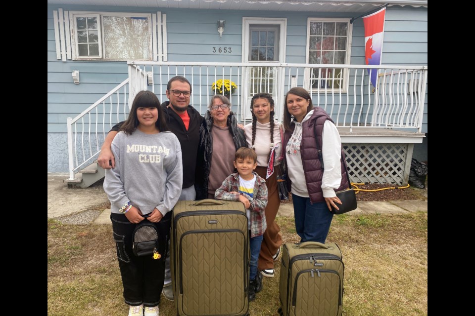 Maryna and Roman Pokynchereda and their three children, from left Yeva, Pasha and Masha, stand with Roman's mother Lydiia in front of the Prince George home they bought in Pinewood last spring. From left 