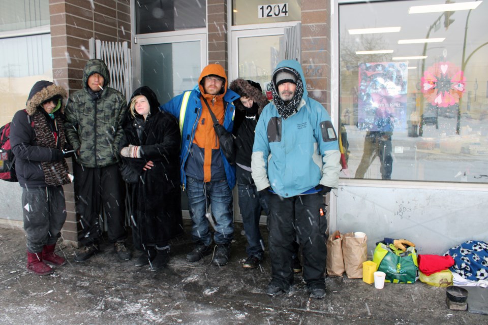 Kurt Kriberg, third from right, waits for lunch with his friends in front of the St. Vincent de Paul Drop-In Centre at 1220 Second Ave.