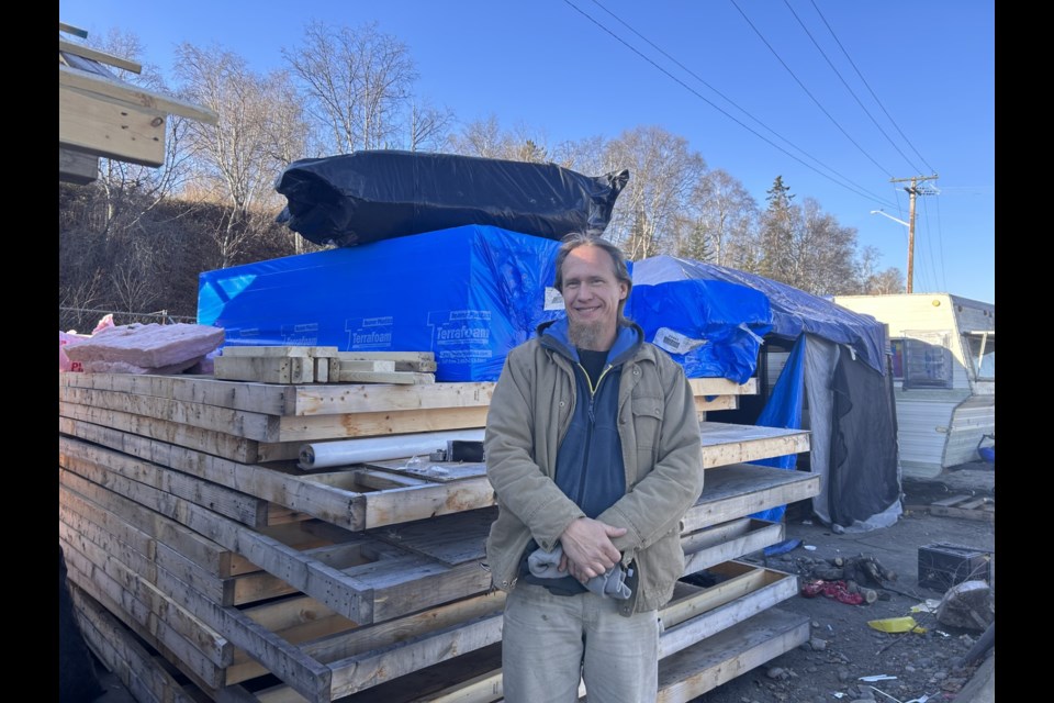 Brad Gustafson stands near donated building materials. 