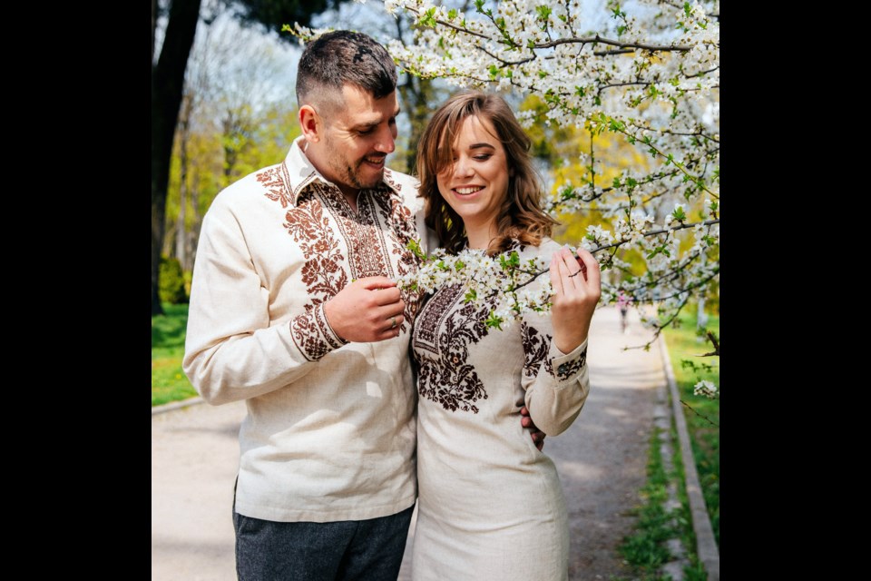 Vasyl and Iryna Derunets take time to admire the spring blossoms in happier times in their home. 