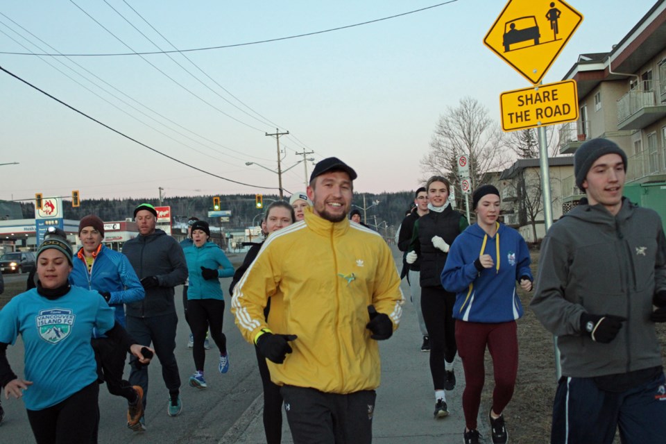 Vova Pluzhnikov and some supporters run along 15th Avenue in Prince George at the start of the Run For Ukraine in March 2022.