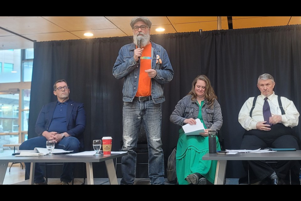 NDP candidate Cory Grizz Longley stands to answer a question in the Prince George-Peace River-Northern Rockies all-candidates forum on Wednesday, Aoril 24, 2025 at the UNBC agora. On the left in incumbent Conservative candidate Bob Zimmer, near right is Green candidate Mary Forbes and at far right is People's Party of Canada candidate David Watson.