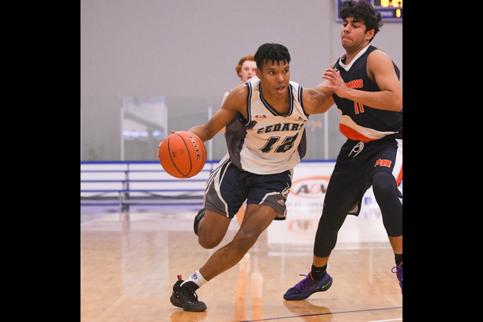 Tony Kibonge of the Cedars Christian Eagles dribbles the ball in on Raajin Hoonjin of the Aberdeen Hall Gryphons  during their game Thursday at the B.C. boys high school basketball single-A championship in Langley.