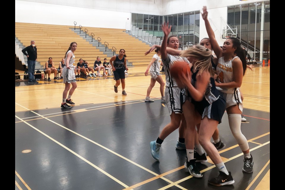 Haley Strand of the College Heights Cougars gets into a hairy situation and draws a crowd of Duchess Park Condor defenders during Thursday's North Central triple-A girls basketball zone championship opener at Duchess Park. The Cougars won 100-38.