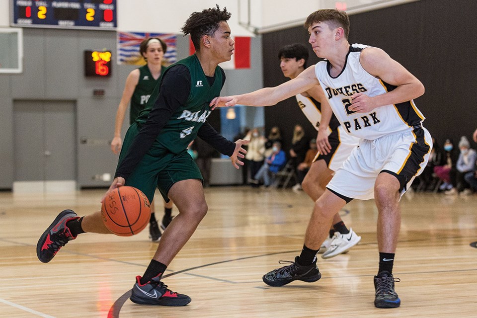 Citizen Photo by James Doyle. PGSS Polars player Daniel Traore drives to the basket against Duchess Park Condors defender Daniel Dron on Saturday afternoon at the Shas Ti Kelly Road gymnasium in the final game of the Junior A Boys Megabowl basketball tournament.