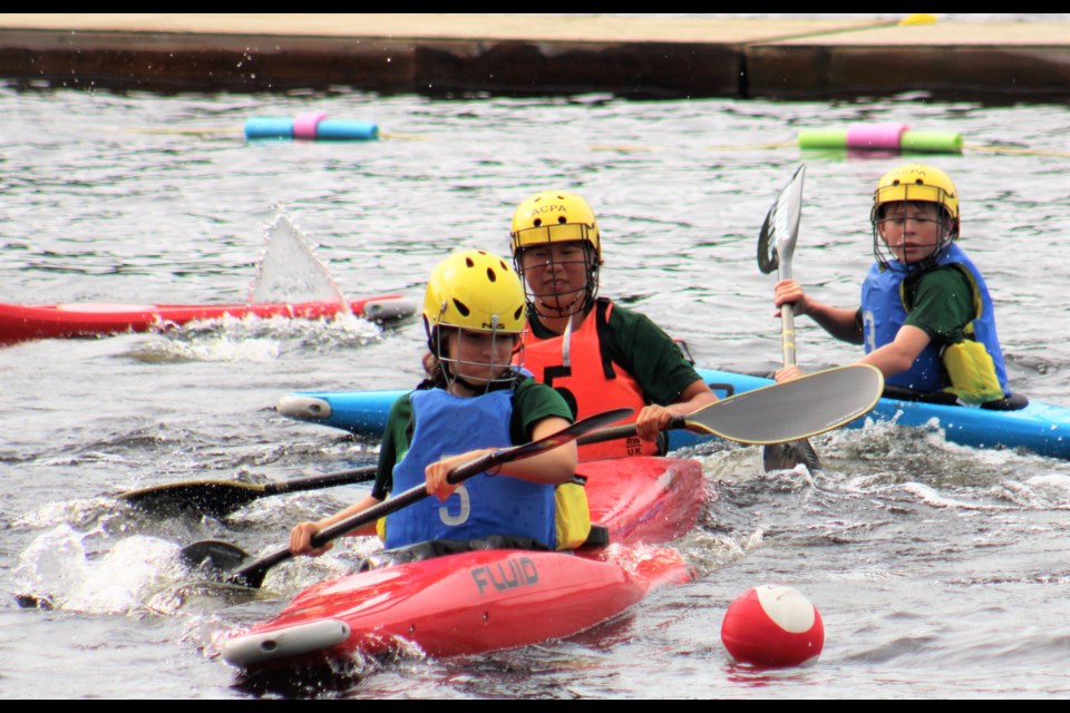 Paddlers chase after the ball in kayak polo Sunday at Nadsilnich Lake during the BC Summer Games.