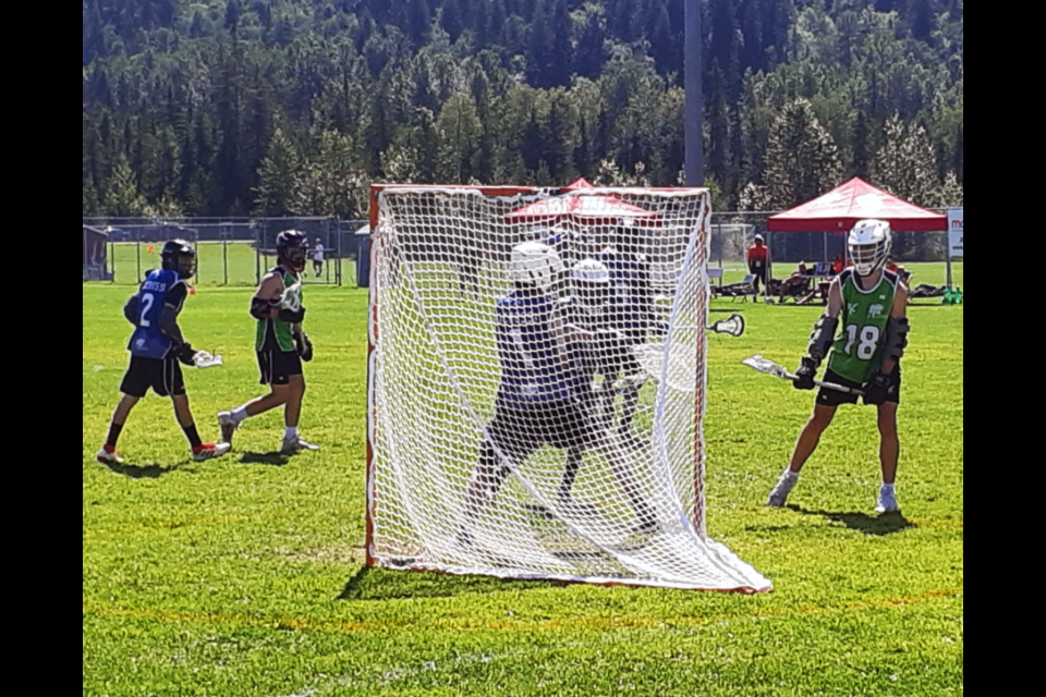 Jax Heavenor of Vancouver Island Central Coast scores on Cariboo-Northeast goalie Breton MacPherson while Vancouver Island attack Deo Toth, right, waits for a possible rebound during their BC Summer Games field lacrosse game Friday afternoon at Glen Thompson Field.