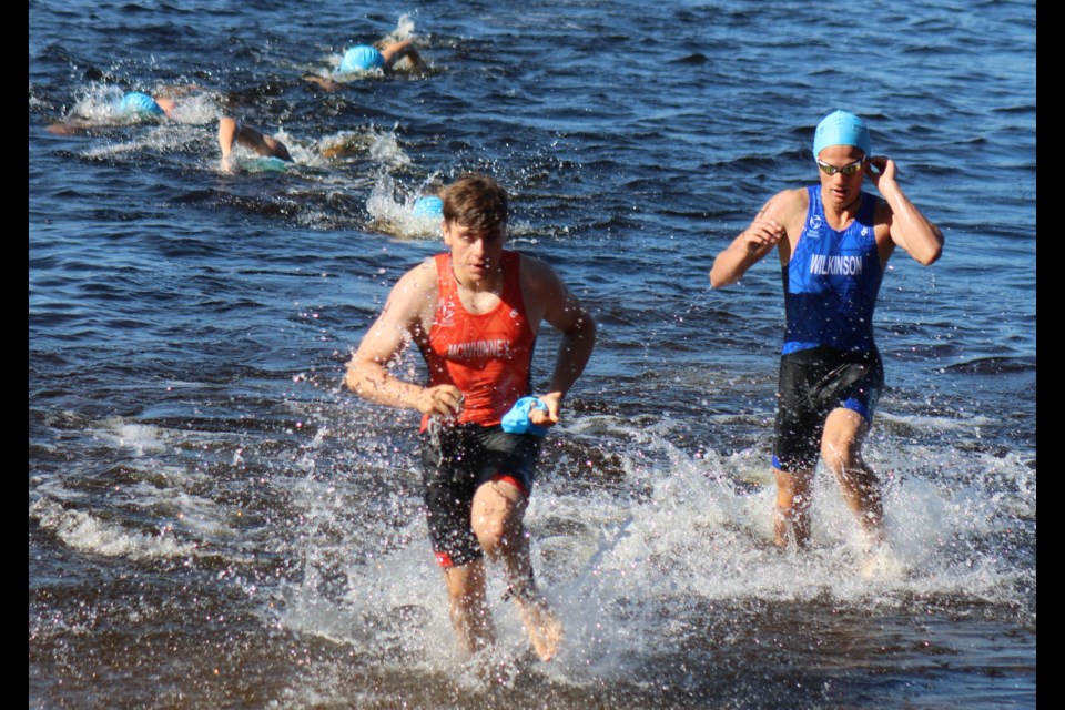 Josiah Wilkinson, right, emerges from Nadsilnich Lake during the F1 junior boys triathlon at the BC Summer Games on Saturday.
