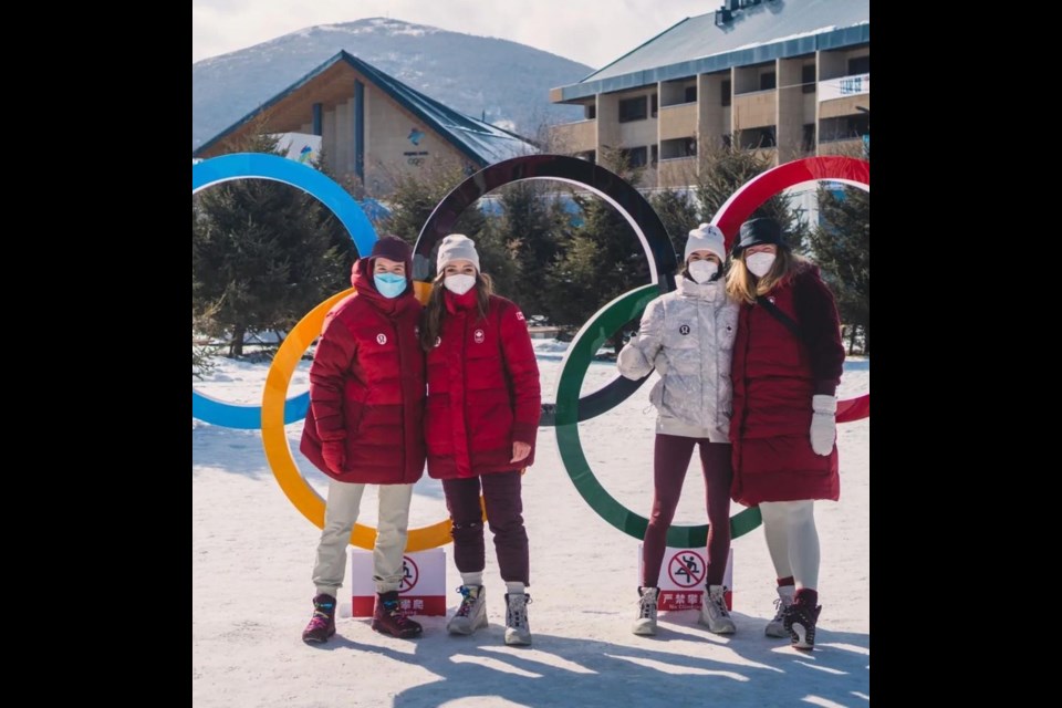 Canadian biathlon team athletes, from left, Adam Runnalls, Emily Dickson, Megan Bankes and Sarah Beaudry strike a pose in front of the Olympic rings at the mountain athletes village in China. 
