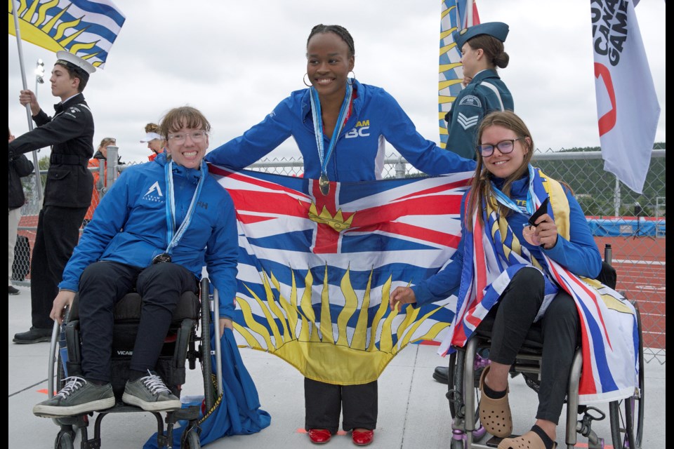 Bronze medalist Brooke Perepeluk of Prince George, right, shares the Canada Summer Games 100-metre wheelchair podium with silver medalist Britney Volkman of Leduc, Alta., and gold medalist Jessi Guerrier of Burnaby after they were presented their medals on Friday, Aug. 22 in St. John's Nfld.