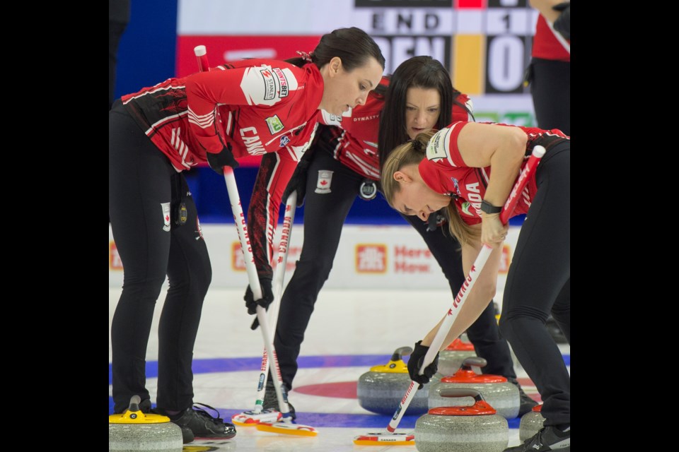 Team Canada skip Kerri Einarson of Gimli, Man., stands in the rings as, from left, third Val Sweeting and lead Briane Meilleur bring the stone into the house during their game Monday afternoon against Denmark at the 2022 BKT Tires & OK Tire World Woman's Curling Championship at CN Centre.