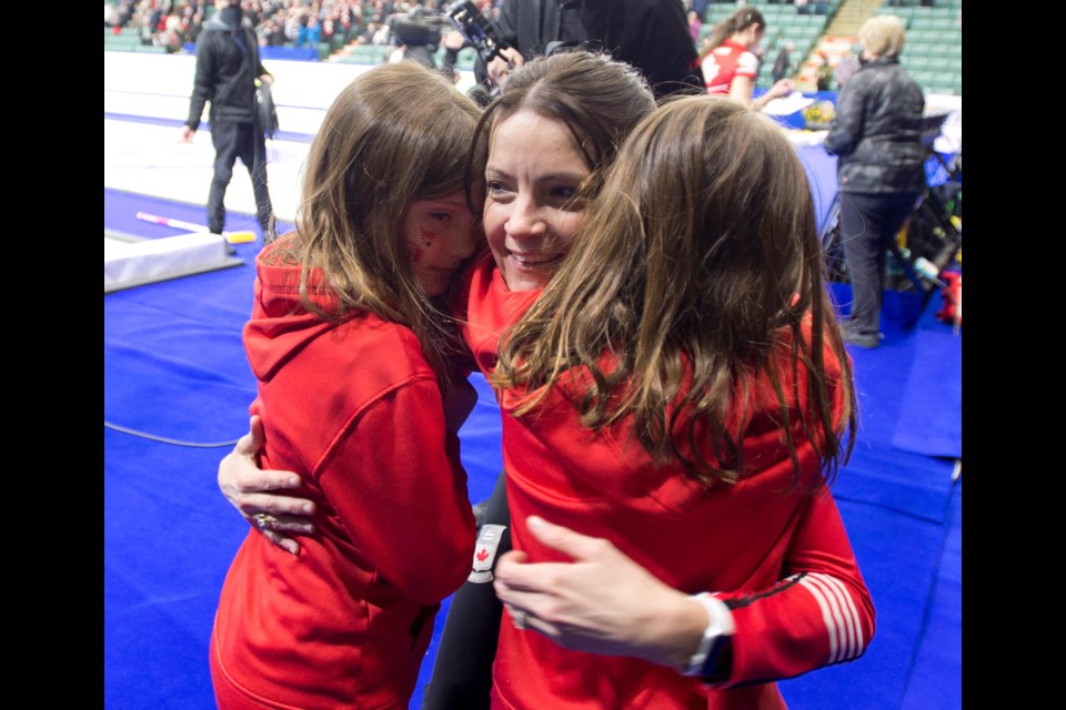 Kerri Einarson hugs her twin eight-year-old daughters, Khloe and Kamryn, after she and her Team Canada rinkmates clinched a broze-medal win over Sweden Sunday at the BTK Tires & OK Tire World Women's Curling Championship at CN Centre. 