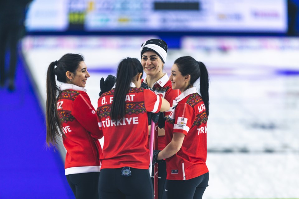 Team Turkey shares a happy moment on the ice during their game against Canada on Sunday at the BKT Tires & OK Tire World Women's Curling Championship at CN Centre.