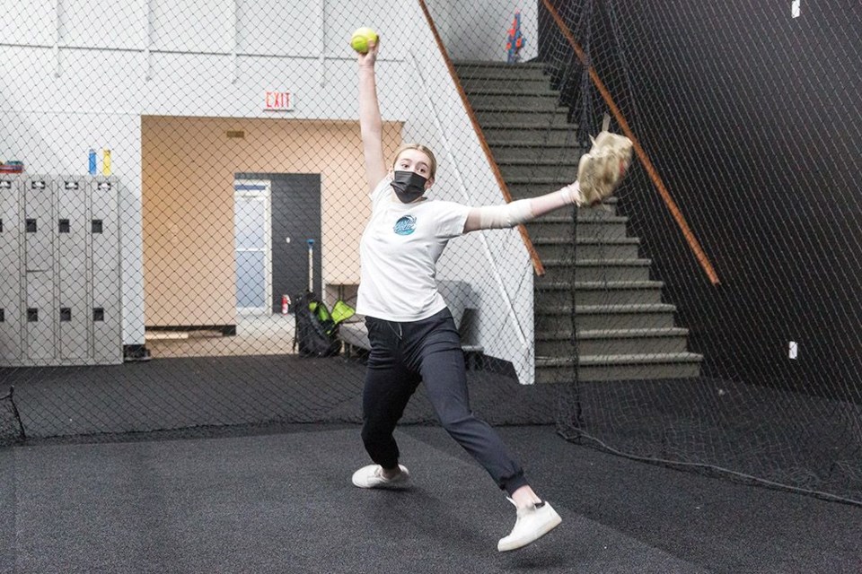 Corina McClure goes through her windup while pitching in the cage at Northern Baseball Academy on Nicholson Street earlier this year.