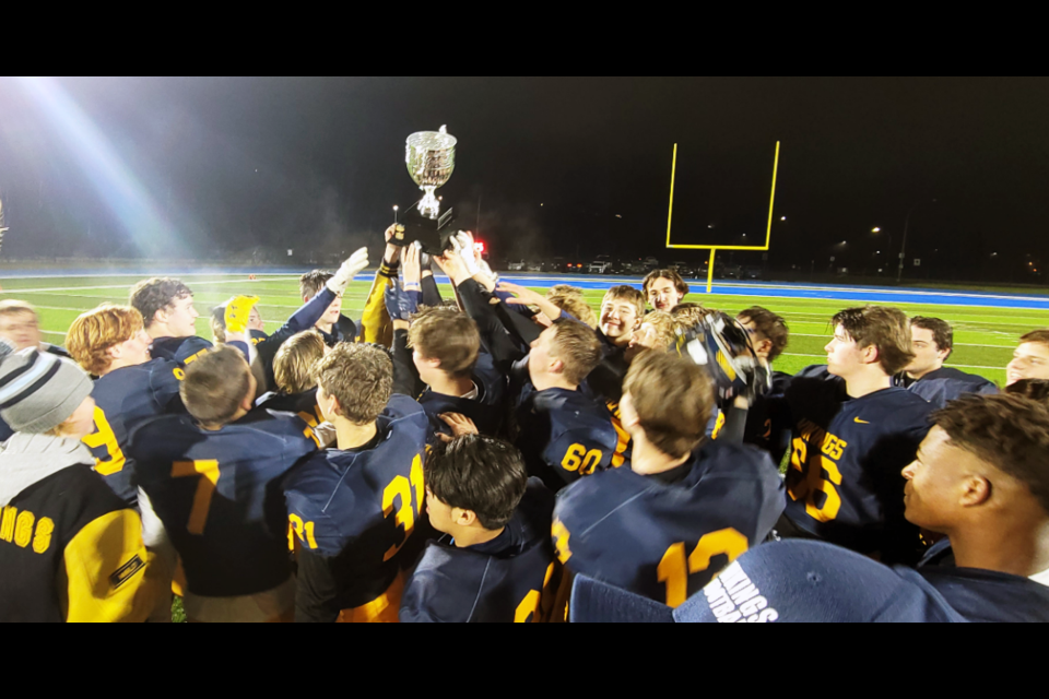The Nechako Valley Vikings gather around the Matt Pearce Memorial Trophy as they celebrate their 26-0 win over the College Heights Cougars in the P.G. Bowl final Friday at Masich Place Stadium.