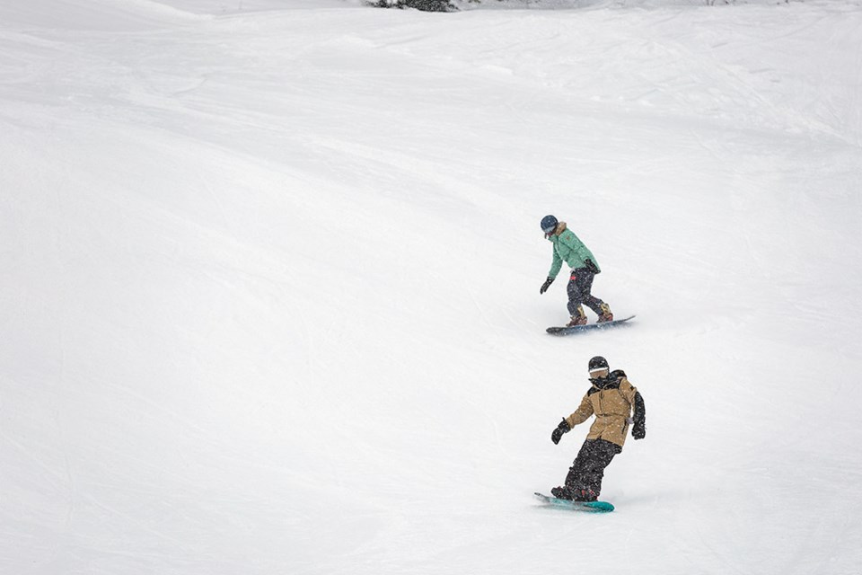 Citizen Photo by James Doyle. A pair of snowboarders make their way down the slopes on Saturday morning during opening day at Hart Ski Hill.
