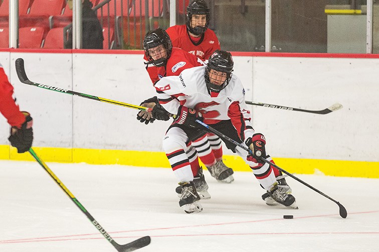 Josh Sale of the Cariboo Cougars considers his option while carrying the puck in the North West Hawks zone during Sunday's game at Kin 1. The Cariboo Cougars defeated the Hawks  3-2 in a shootout.