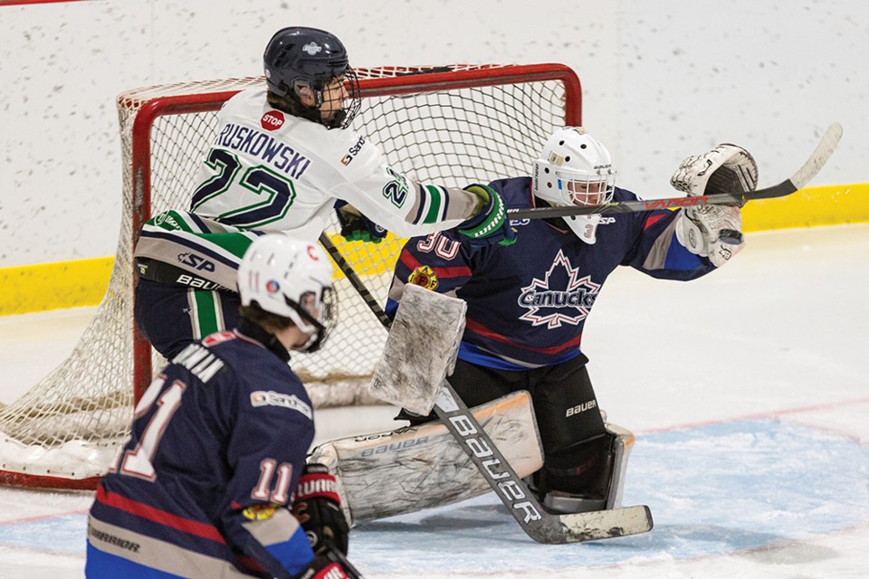 Citizen Photo by James Doyle. Cariboo Cougars goaltender gets a glove on the tip of Fraser Valley Thunderbirds forward Brendan Ruskowski on Sunday afternoon at Fort Forum in Fort St. James as part of the 3rd Annual Northern Winter Classic.