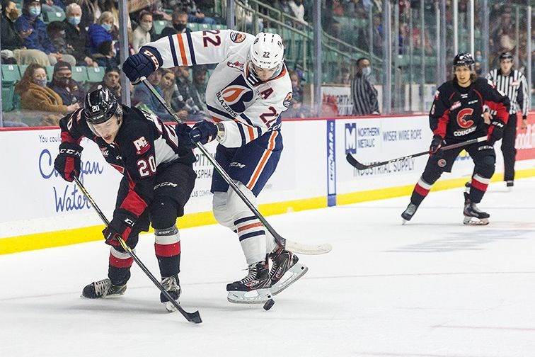 Cougars winger Ficher O'Brien fights off the check of Kamloops Blazers defenceman Daylan Kuefler while Cougar defenceman Viiam Kmec stands guard on the point during Saturday's WHL game at CN Centre.