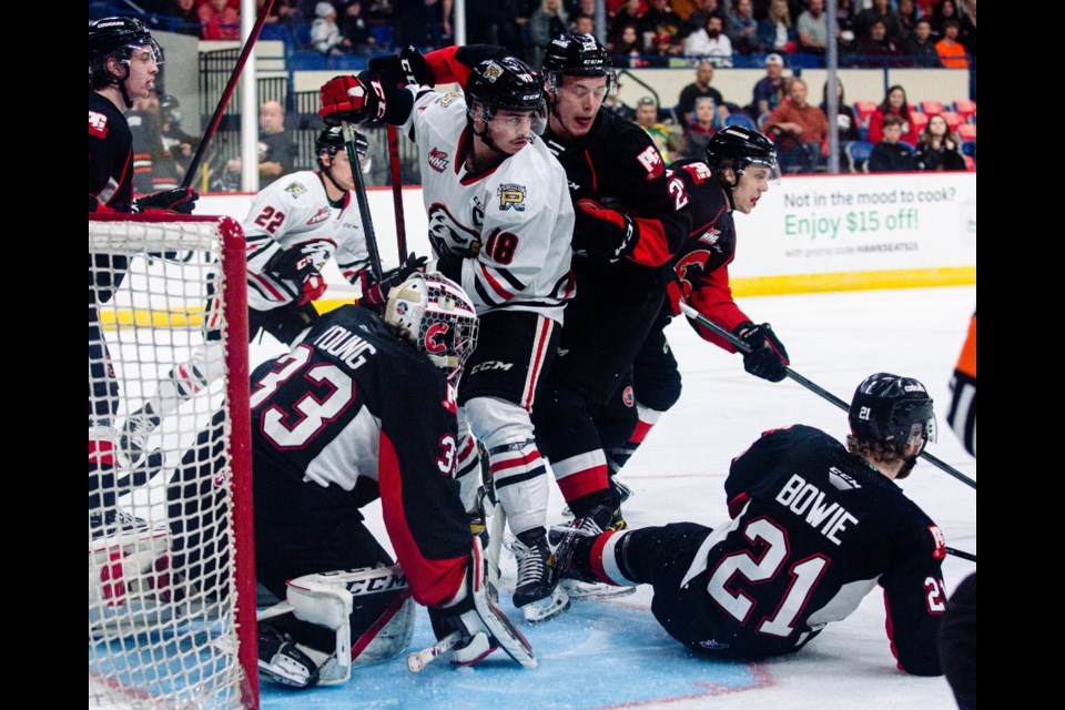 Cougars golaie Ty Young looks for the puck in a pileup of bodies in front of him during the first period Friday in Portland, Ore. The Cougars lost 5-2 to the Portland Winterhwaks in the series-opening game. 