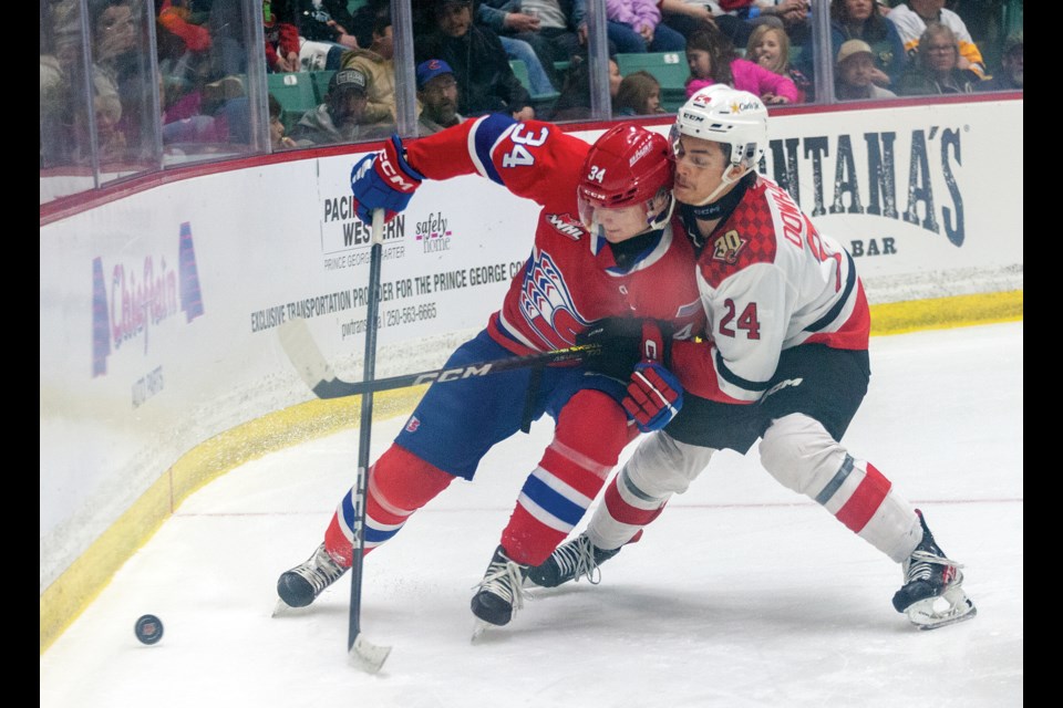 Prince George Cougars defenceman Keaton Dowhaniuk tries to force Spokane Chiefs forward Connor Roulette into the boards behind the goal during second-period action Saturday at CN Centre.

Citizen photo by Chuck Nisbett