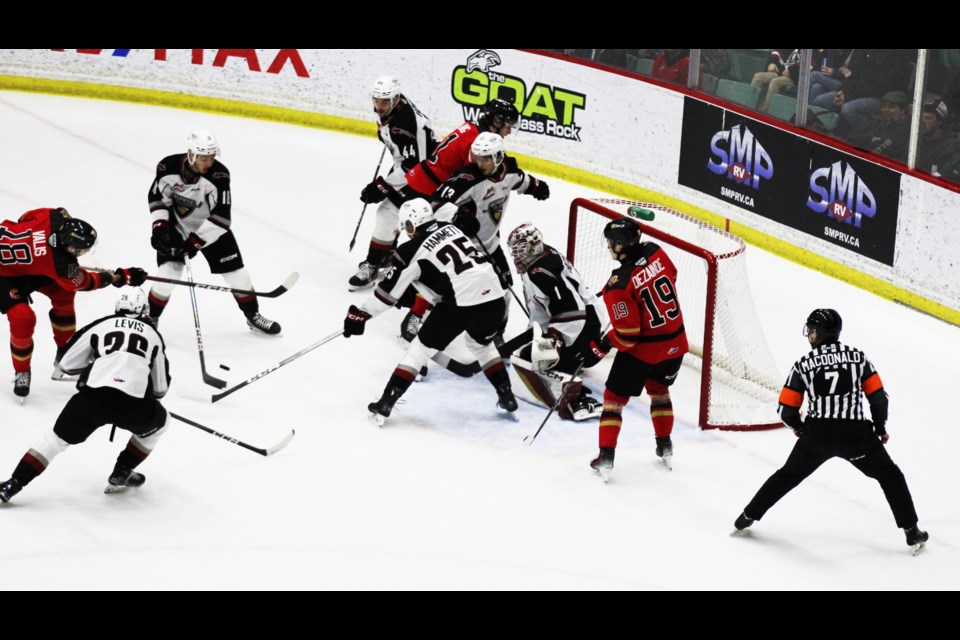 Cougars forward Borya Valis lets go a shot from the slot while cluster of players gathers in front of Vancouver Giants goalie Matthew Hutchinson during first-period action Saturday at CN Centre. The Cougars opened up a 4-1 lead after 20 minutes and cruised to  ????? victory.