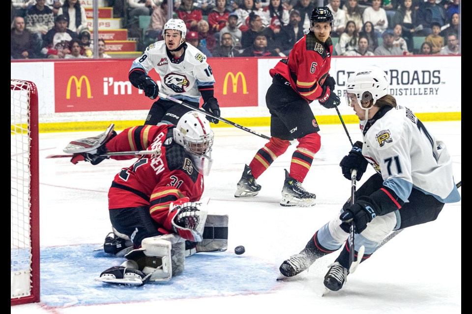 Prince Gerge Cougars goalie Josh Ravensbergen blocks a shot from Portland Winterhawks forward Josh Davies during first-period action of Game 6 in their WHL Western Conference final series at CN Centre Monday at CN Centre. Portland won the game 2-1 in second overtime taking the series 4-2.
