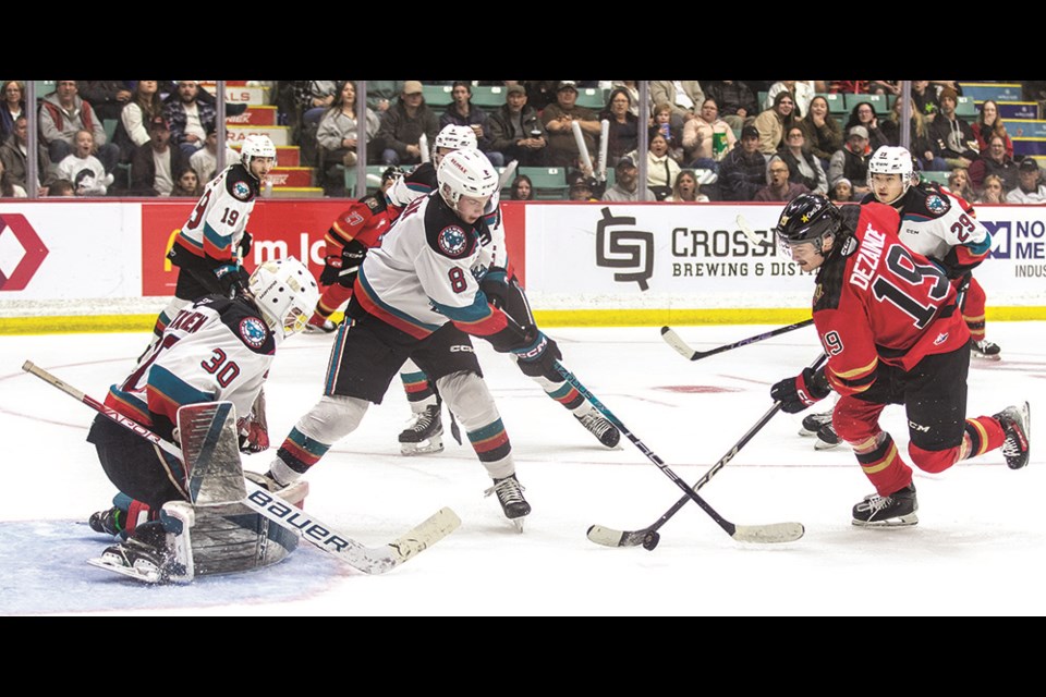 Prince George Cougars left winger Carlin Dezainde gets a shot lined up as Kelowna Rockets defenceman Marek Rocak tries to force his stick off the puck and goalie Jari Kykkanen lines up to block during second-period action in Game 1 of their second-round series at CN Centre Friday.
