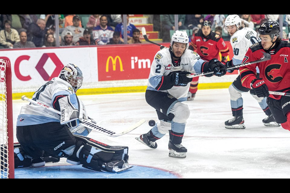 Winterhawks goalie Jan Spunar deflects a shot as defenceman Josh Mori tries to capture the airborne puck and Cougars forward Riley Heidt rushes in to get to it during second period action Saturday at CN Centre.
