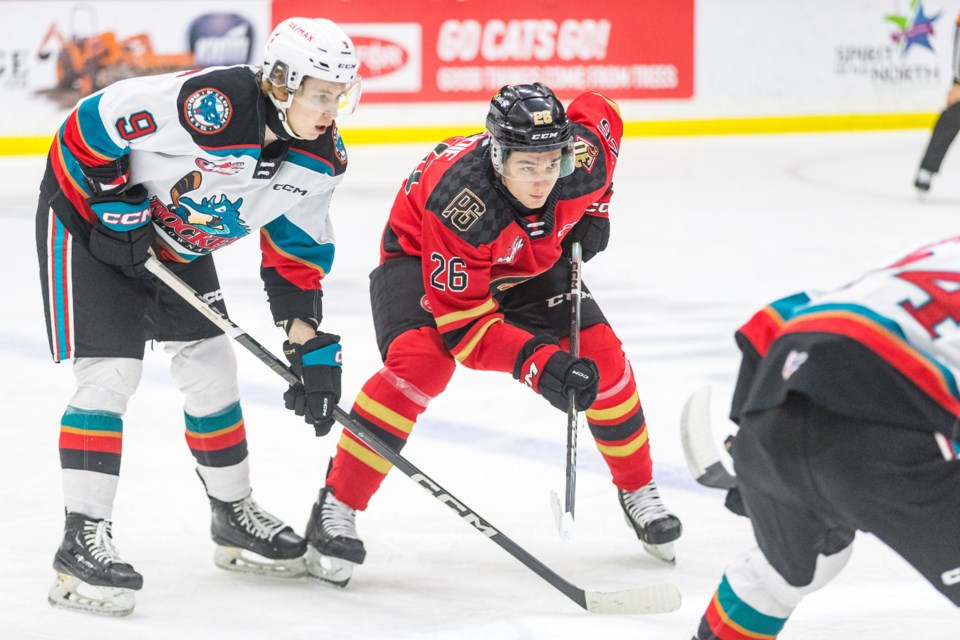 Cougars winger Jett Lajoie, right, lines up for a face-off against Kelowna Rockets forward Brett Calhoon during a game earlier this season at CN Centre.