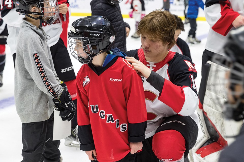 Citizen Photo by James Doyle. Prince George Cougars forward Koehn Ziemmer signs the jersey of a young fan on Sunday afternoon during the Cougars Fan Appreciation game.