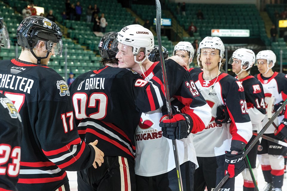 Citizen Photo by James Doyle. Prince George Cougars defender Jonas Brondberg shares a hug with Portland Winterhawks forward Jack O'Brien on Wednesday evening at CN Centre after the Winterhawks defeated the Cougars by a score of 2-1 to sweep their Western Conference Quarter Final series 4-0.