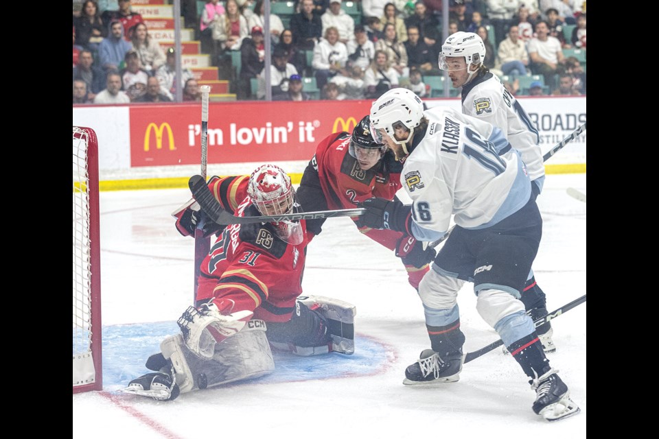 Cougars goalie Josh Ravensbergen makes one of his 33 saves to deny Portland Winterhawks forward Gabe Klassen while Cats defenceman Bauer Dumanski looks on during Game 1 action Friday at CN Centre. The Cougars shut out the Hawks 5-0 to take a 1-0 lead in the best-of-seven WHL Western Conference final.