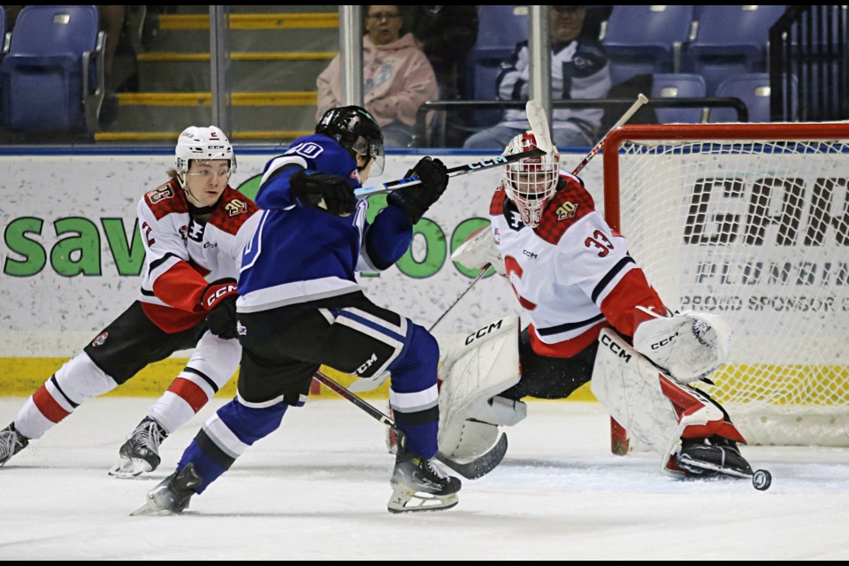 Victoria Royals’ Capser Evensen Haugen shoots on Prince George Cougars’ goaltender Ty Young and Bauer Dumanski (L), during their WHL game Saturday at Save on Foods Memorial Centre in Victoria.