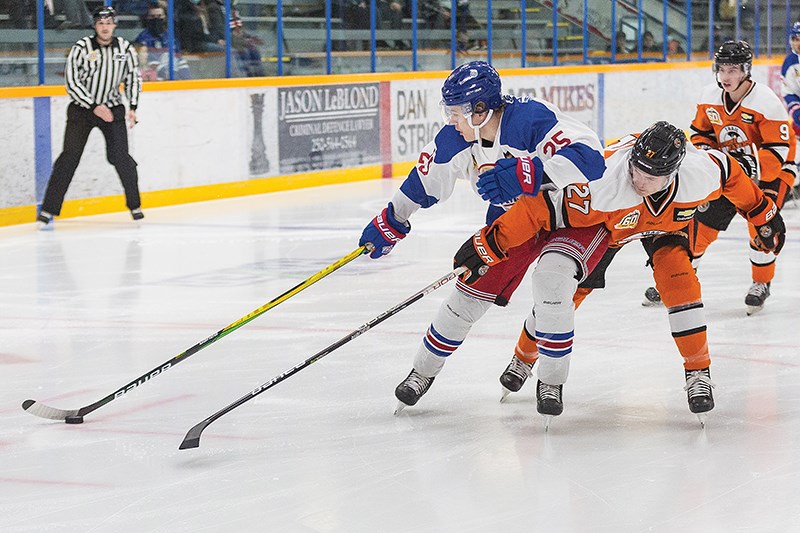 Citizen Photo by James Doyle/Local Journalism Initiative. Prince George Spruce Kings forward Nick Rheaume protects the puck from the outstretched stick of Trail Smoke Eaters defender Evan Bushy on Friday night at Rolling Mix Concrete Arena during the team's 70's Night which saw the team wear 70's retro jerseys. 