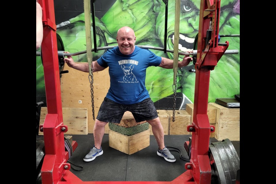 Mike Webber, world champion power lifter, does some squats at his gym in downtown Prince George, XConditioning.