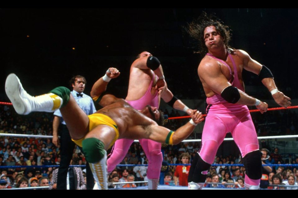 Bret "The Hitman" Hart beats up on an opponent with World Wrestling Federation tag team partner Jim "The Anvil" Neidhart.