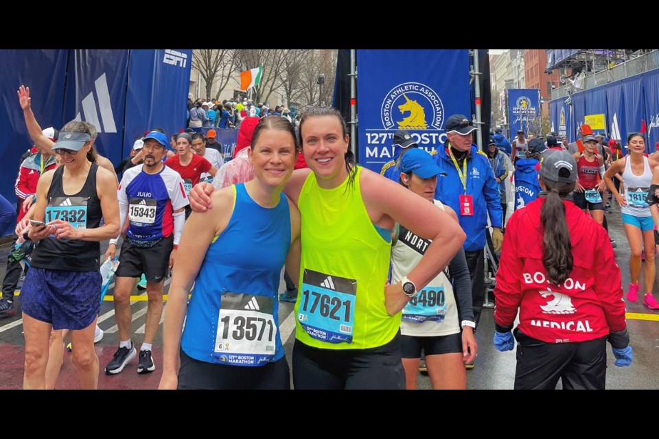 Soaked the the bone after running the 127th Boston Marathon Monday, Dana Doerksen, left, and Pam Mulroy ran the 42.2 km course together and finished in 3:39.