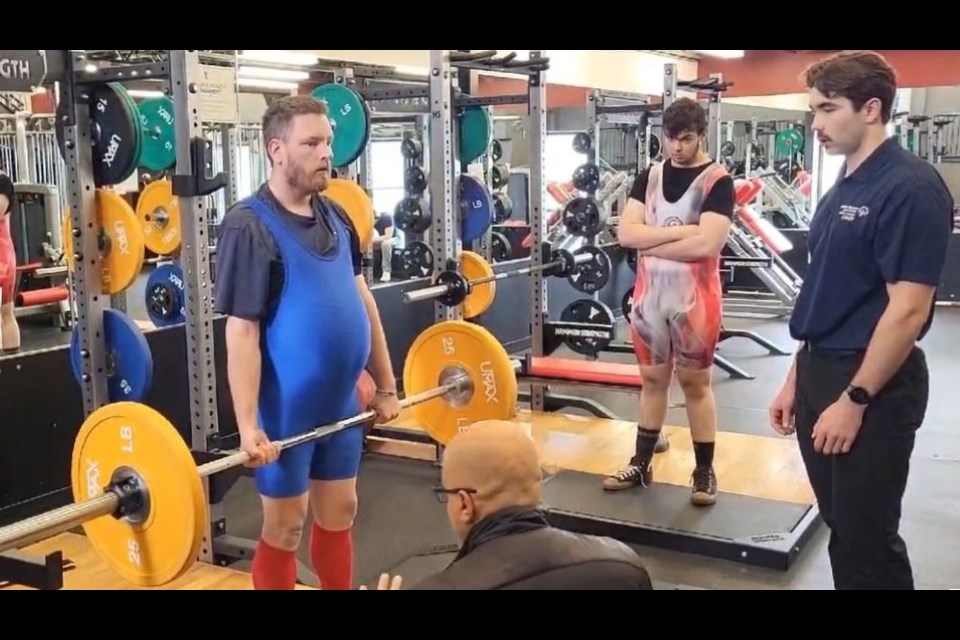 Prince George Special Olympics power lifter Leif Skuggedal demonstrates a lift with his coach Conor McLaughlin, right, guiding him at the Prince George YMCA where the athletes train twice a week ahead of the BC Summer Games on July 10 to 12 in Prince George.
